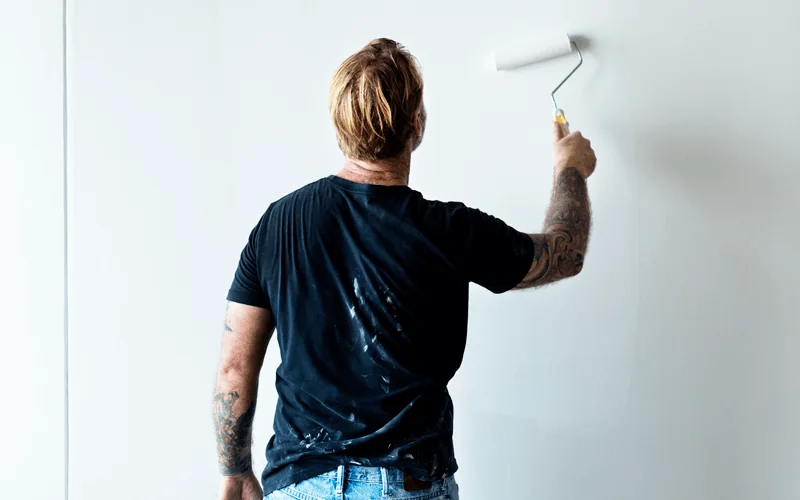 Binnenschilderwerk: schilder werkt een binnenwand egaal af met verf